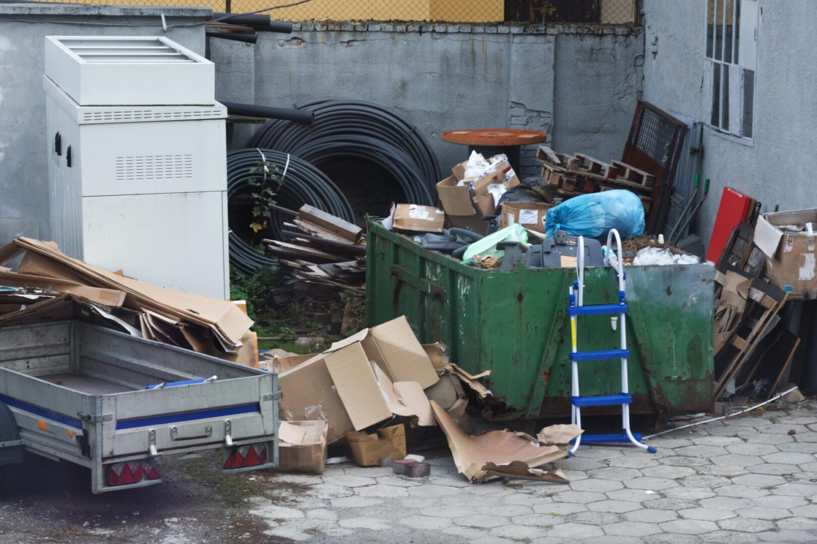 A dumpster full of trash next to a truck.