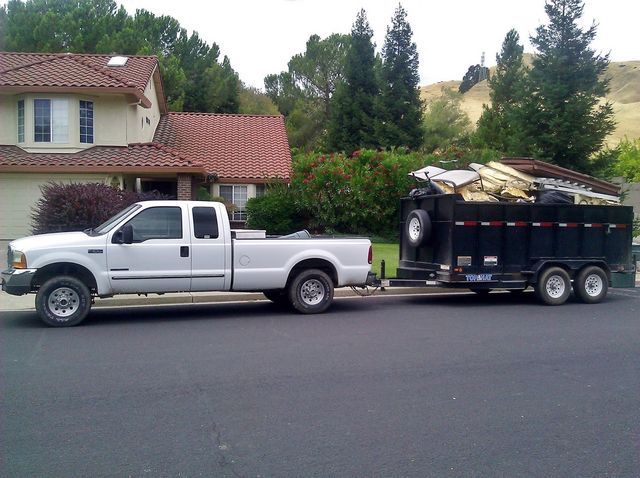 A truck pulling a trailer full of wood.